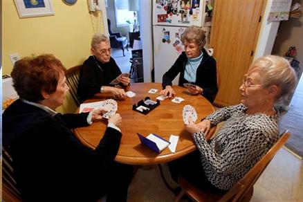 Four Older Adults Playing Cards at Kitchen Table