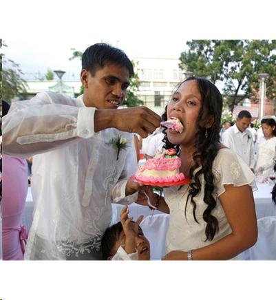 Groom feeding piece of wedding cake to bride.