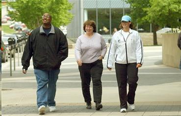 One man and two women who appear to be out for a walk during a lunch break.