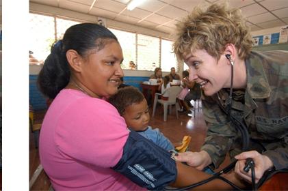 Military personnel woman taking the blood pressure of another adult woman