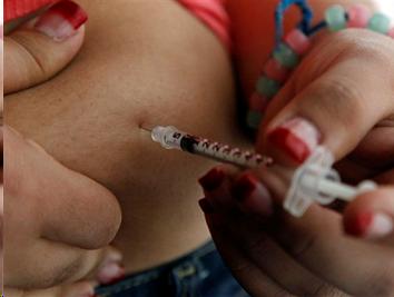 Insulin injection being delivered by a needle into the stomach.